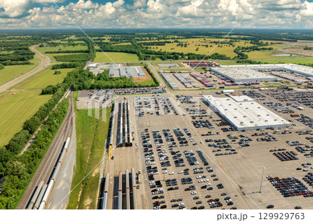 Automotive industry. Import or export of new cars by rail. Train auto racks at production factory warehouse. Vehicles for sale at logistics business parking lot Automotive industry. Import or export of new cars by rail. Train auto racks at production factory warehouse. Vehicles for sale at logistics business parking lot 129929763