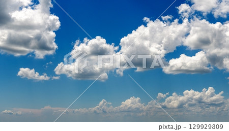 Bright landscape of blue sky with flying white clouds. Colorful summer skyscape 129929809