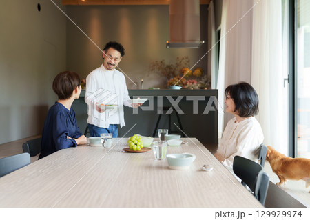 モダンなリビングダイニングで食事をする家族 129929974