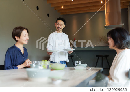 モダンなリビングダイニングで食事をする家族 129929986