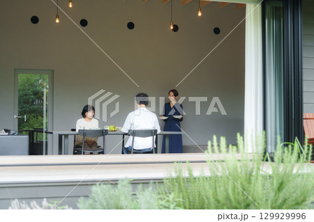 モダンなリビングダイニングで食事をする家族 129929996