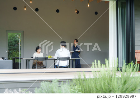 モダンなリビングダイニングで食事をする家族 129929997