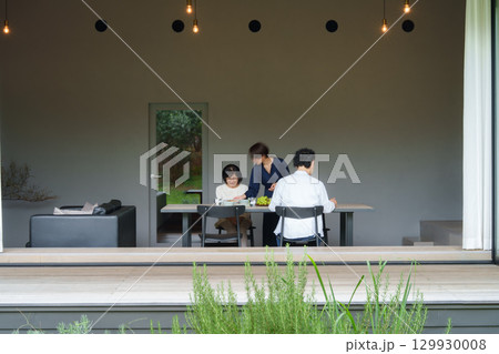モダンなリビングダイニングで食事をする家族 129930008