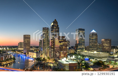 American city skyline with brightly illuminated high commercial buildings and streets. Night urban landscape of downtown district of Tampa in Florida, USA. 129930191