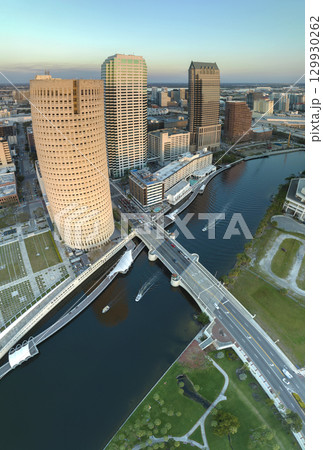 Tampa city in Florida with brightly illuminated skyscraper buildings in downtown district. American megapolis with business financial district at sunset Tampa city in Florida with brightly illuminated skyscraper buildings in downtown district. American megapolis with business financial district at sunset 129930262