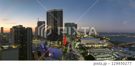 View from above of brightly illuminated skyscraper buildings in downtown district of Miami Brickell in Florida, USA at night. American megapolis with business financial district 129930277