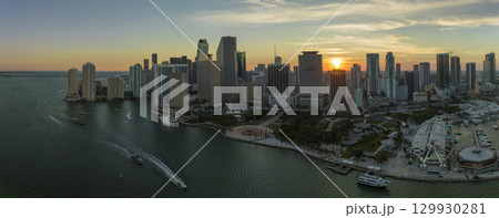 Aerial view of Skyviews Miami Observation Wheel at Bayside Marketplace with reflections in Biscayne Bay water and high illuminated skyscrapers of Brickell, city's financial center at sunset 129930281