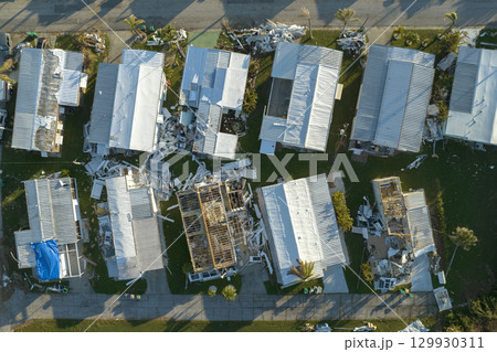 Severely damaged houses after hurricane Ian in Florida mobile home residential area. Consequences of natural disaster 129930311