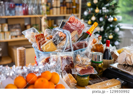 Assortment of goods on counter, basket with products on table near scale, New Year Eve Assortment of goods on counter, basket with products on table near scale, New Year Eve 129930992