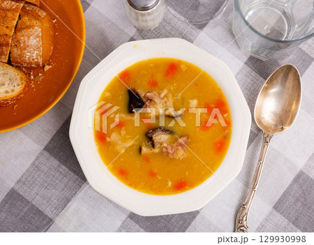 Hot pea soup with smoked meats and vegetables 129930998