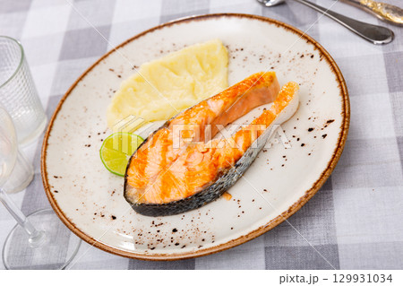 Traditional spanish dish, salmon with mash potatoes served with lemon 129931034