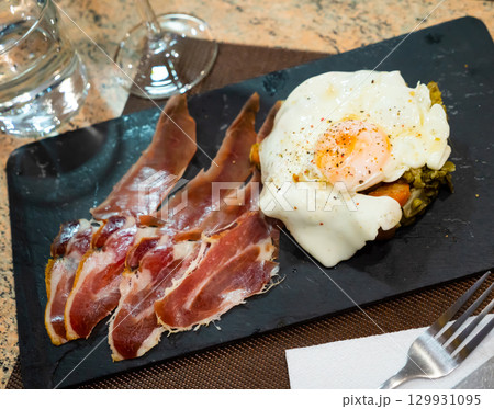 Fried egg with vegetables and ham 129931095