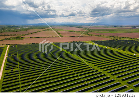 Aerial view of big sustainable electric power plant with many rows of solar photovoltaic panels for producing clean ecological electrical energy. Renewable electricity with zero emission concept. 129931218