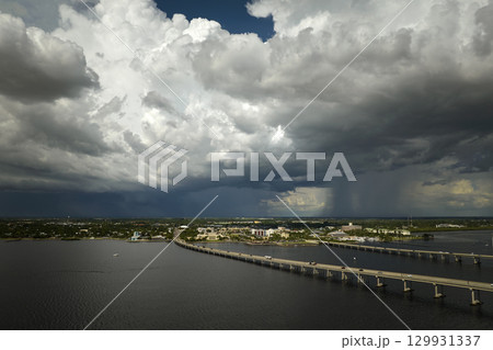 Heavy thunderstorm approaching traffic bridge connecting Punta Gorda and Port Charlotte over Peace River. Bad weather conditions for driving during rainy season in Florida Heavy thunderstorm approaching traffic bridge connecting Punta Gorda and Port Charlotte over Peace River. Bad weather conditions for driving during rainy season in Florida 129931337