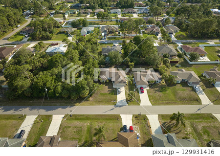 Aerial view of suburban landscape with private homes between green palm trees in Florida quiet residential area Aerial view of suburban landscape with private homes between green palm trees in Florida quiet residential area 129931416