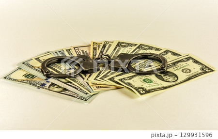 Metal handcuffs on the banknotes of US dollars Metal handcuffs on the banknotes of US dollars 129931596