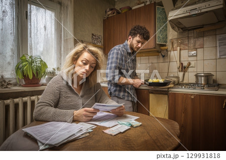A Couple Who Are Actively Managing Their Finances in a Warm and Cozy Kitchen Setting 129931818