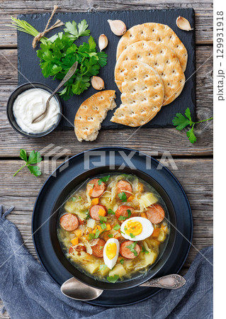 Polish sauerkraut soup with sausage in a bowl 129931918