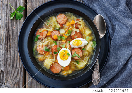 Polish sauerkraut soup with sausage in a bowl 129931921