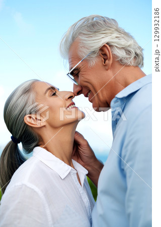 Senior Couple Enjoying a Joyful Moment Together Outdoors in a Sunny Landscape 129932186