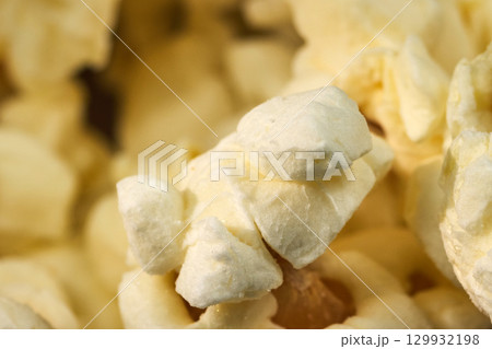 Fluffy white popcorn pieces fill a bowl, invitingly arranged for a movie night or snack time at home Fluffy white popcorn pieces fill a bowl, invitingly arranged for a movie night or snack time at home 129932198