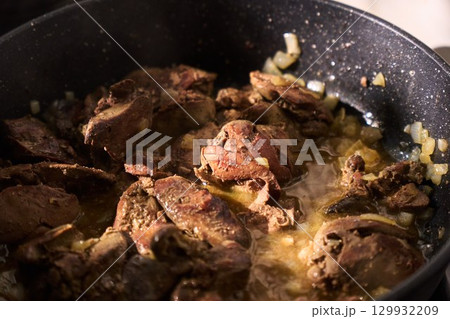 Cooking liver in a frying pan with herbs and spices for a savory dish 129932209
