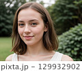 Young Woman Smiling in a Green Outdoor Setting 129932902