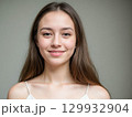 Smiling Young Woman Portrait on Gray Background 129932904