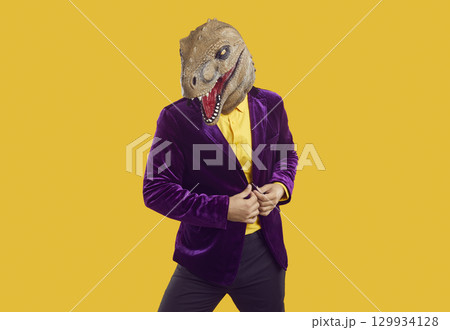 Portrait of funny man wearing purple suit and dinosaur mask posing in fashion studio Portrait of funny man wearing purple suit and dinosaur mask posing in fashion studio 129934128