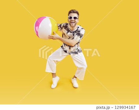 Happy excited man in sunglasses holding inflatable sea ball 129934167