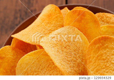 Fried Salty Potato Chips Close-Up Junk Food Treat Detail Fried Salty Potato Chips Close-Up Junk Food Treat Detail 129934329
