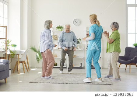 Happy Seniors Dancing With Doctor Or Nurse In Senior Home 129935063