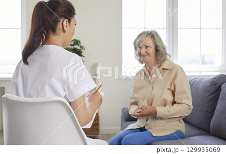 Senior people care, young kind nurse, geriatric medicine caretaker talking to old woman 129935069