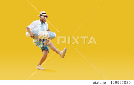 Funny man in sunglasses holding rubber ring and having fun on studio yellow background. Funny man in sunglasses holding rubber ring and having fun on studio yellow background. 129935080