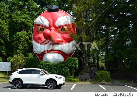大きな天狗面と白い自動車 129935108