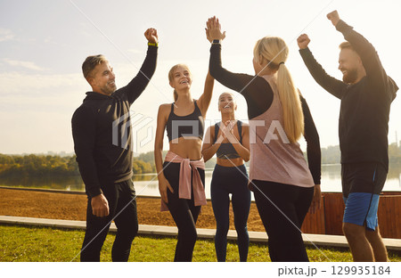 Sporting Friends Exchange High Five in the Park 129935184