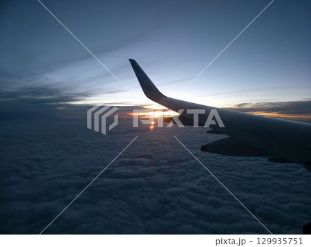 雲海に沈む夕日と飛行機の翼 雲海に沈む夕日と飛行機の翼 129935751