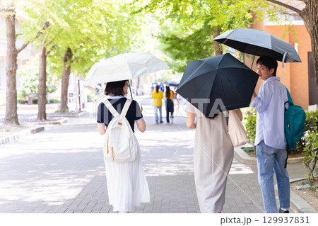 日傘をさす男女 日傘をさす男女 129937831