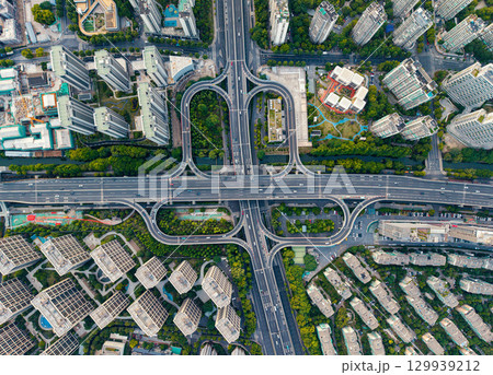 Aerial top down view of a busy junction reveals a multitude of vehicles traveling on various roadways. Hangzhou, China. 129939212