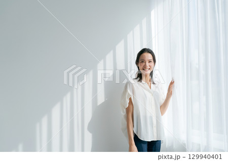 窓際に立つ女性 窓際に立つ女性 129940401