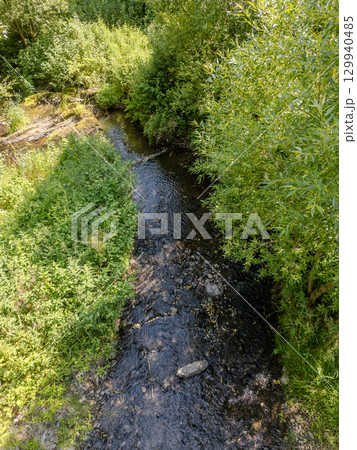 Thommen, Liege, Belgium, A Tranquil Stream Flowing Gently Through Lush Greenery and Vibrant Natural Thommen, Liege, Belgium, A Tranquil Stream Flowing Gently Through Lush Greenery and Vibrant Natural 129940485