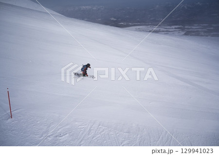 ニセコ東急 グラン・ヒラフのダイナミックコースを滑走するスキーパトロール 129941023