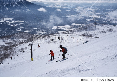 ニセコ東急 グラン・ヒラフのダイナミックコースを滑走するスキーパトロール 129941029