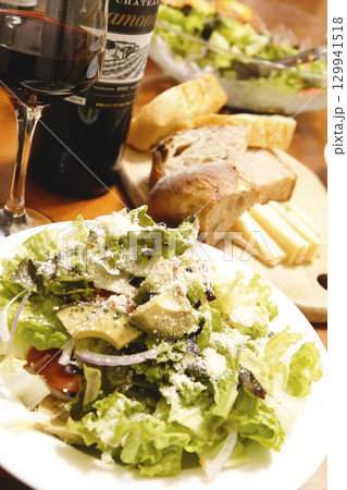 食卓に並べられた前菜のサラダ パンとチーズ ワイン 129941518