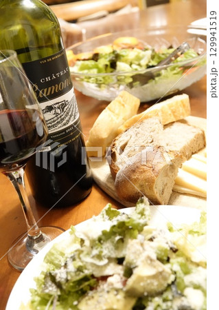 食卓に並べられた前菜のサラダ パンとチーズ ワイン 129941519