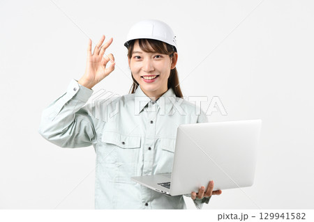 作業服姿のアジア人女性がPCを持ちOKサインをするイメージ 129941582