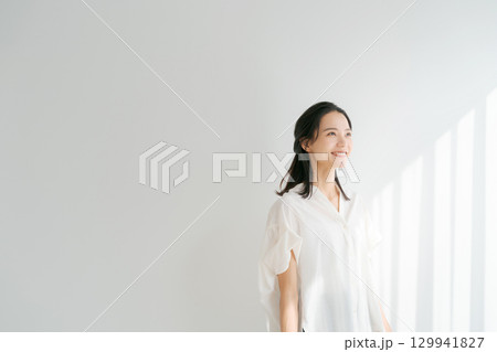 窓辺に日差しを浴びる女性 129941827