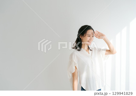 窓辺に日差しを浴びる女性 129941829