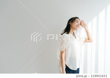 窓辺に日差しを浴びる女性 窓辺に日差しを浴びる女性 129941831