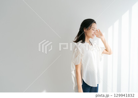 窓辺に日差しを浴びる女性 129941832